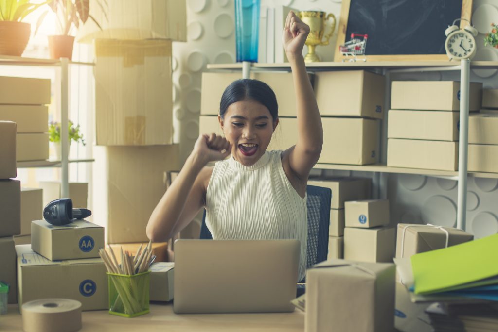 Image of a business woman working in home office. She is happy and success with their online store. Concept of freelancer startup and online business.