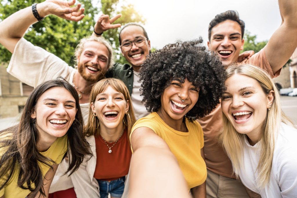 friends smiling at camera together outside - Happy young people taking selfie with smart mobile phone device walking on city street - Youth community and technology concept